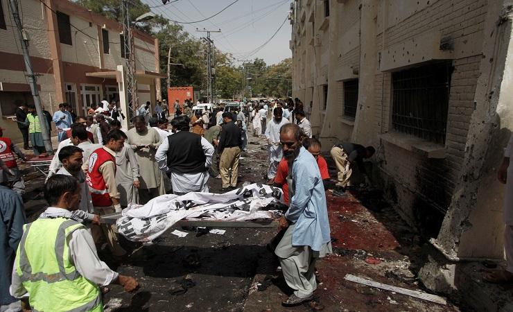 Respon dan relawan pertama memindahkan korban terluka dan meninggal dari lokasi kejadian dimana bom 