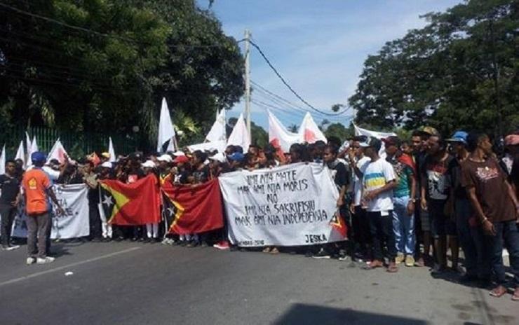 Peserta peringatan Tragedi Santa Cruz di Timor Leste membawa spanduk yang berarti: Kematian kalian a