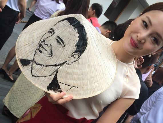 Seniman Vietnam Lan Phuong menggambar wajah Presiden Obama di topi khas Vietnam. (Foto: Lien Hoang)