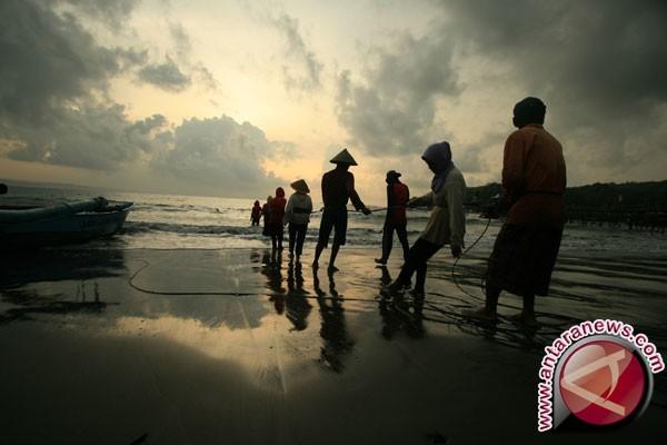 Nelayan menarik pukat dari darat di pantai Pangandaran, Ciamis, Jawa Barat, Rabu (23/10). (Antara)