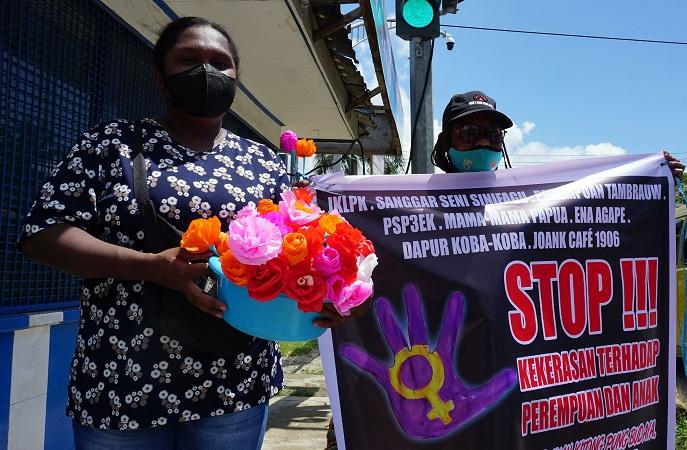 Aktivis melakukan aksi simpatik dengan membagikan bunga di salah satu jalan di Kota Sorong, Papua Ba