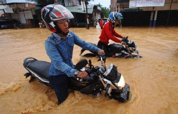 Pengendara motor nekat melewati banjir yang merendam Jalan Adinegoro, Padang, Sumatera Barat, Selasa