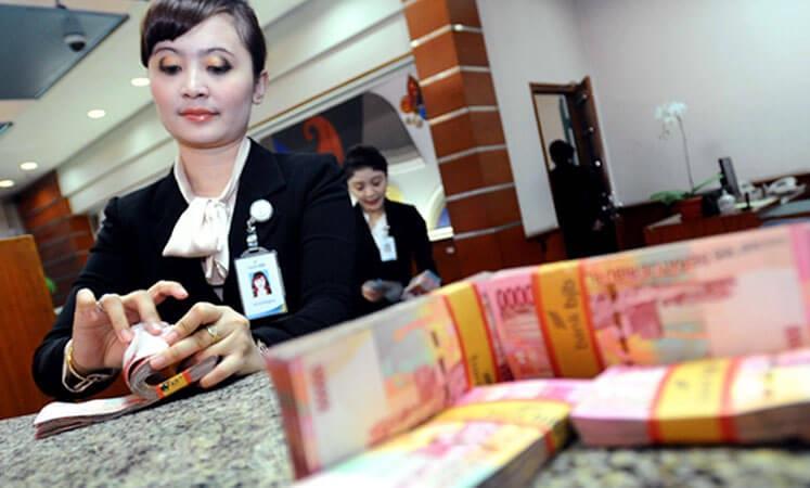 Ilustrasi: Petugas bank menghitung lembaran mata uang rupiah. (Foto: setkab.go.id)