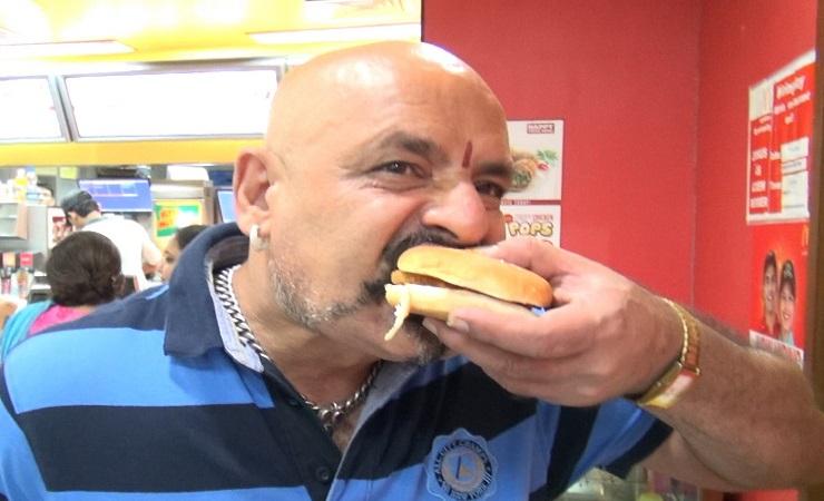 Seorang pria India sedang menyantap burger. (Foto: Jasvinder Sehgal)