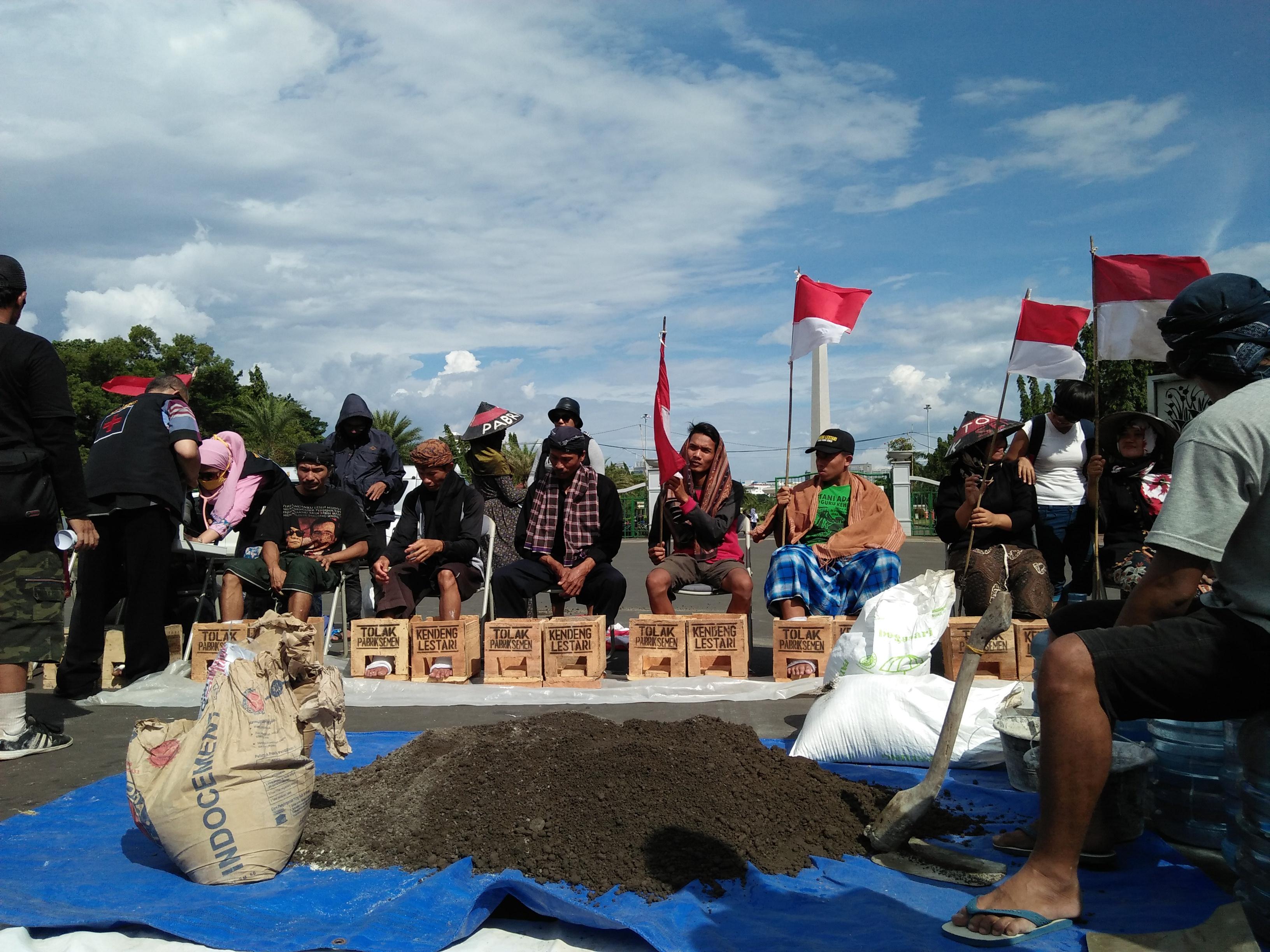 Farmers from central Java cement their feet in protest of a cement factory being established, which 