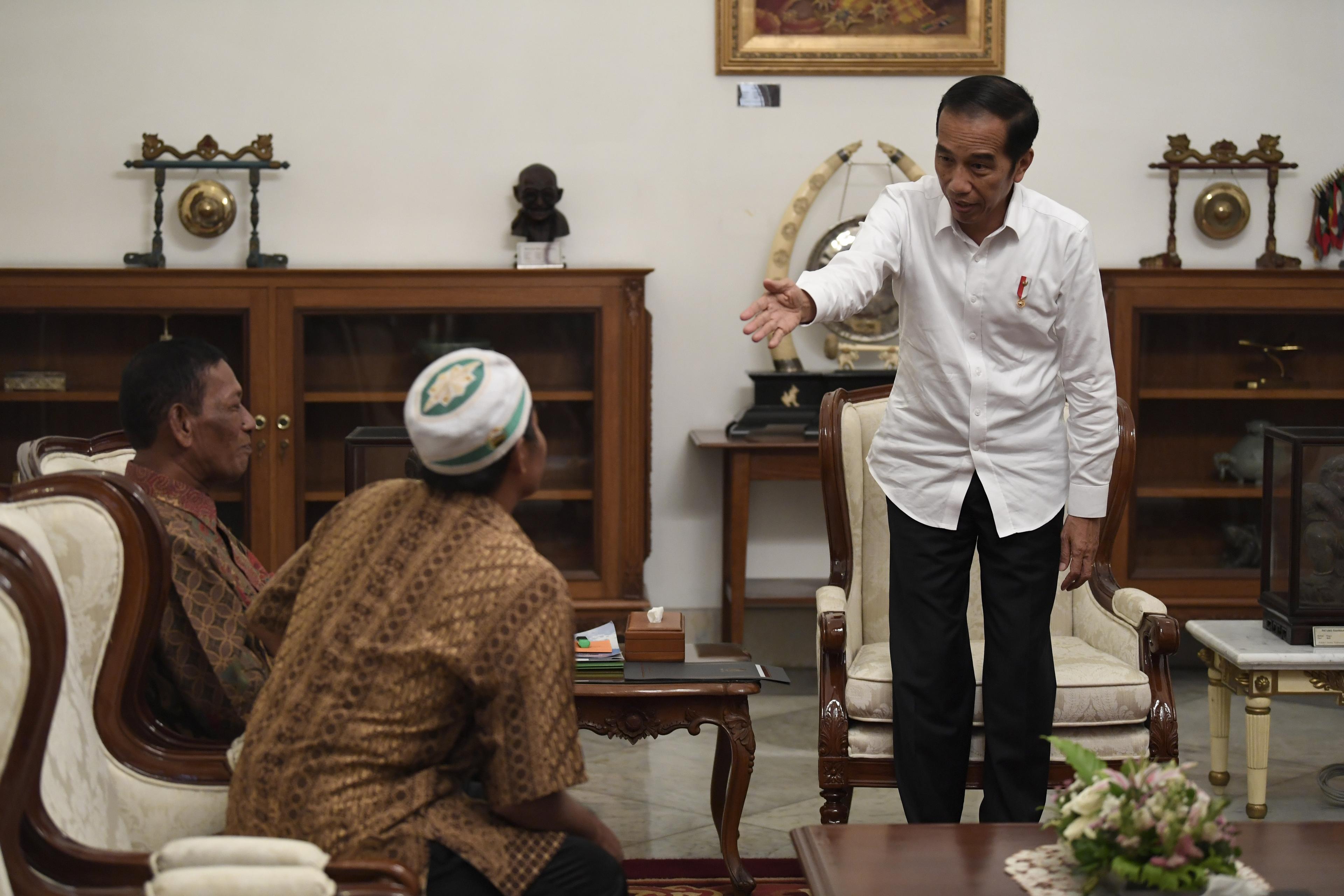 Presiden Joko Widodo (kanan) menerima pedagang kaki lima yang menjadi korban penjarahan saat aksi 22