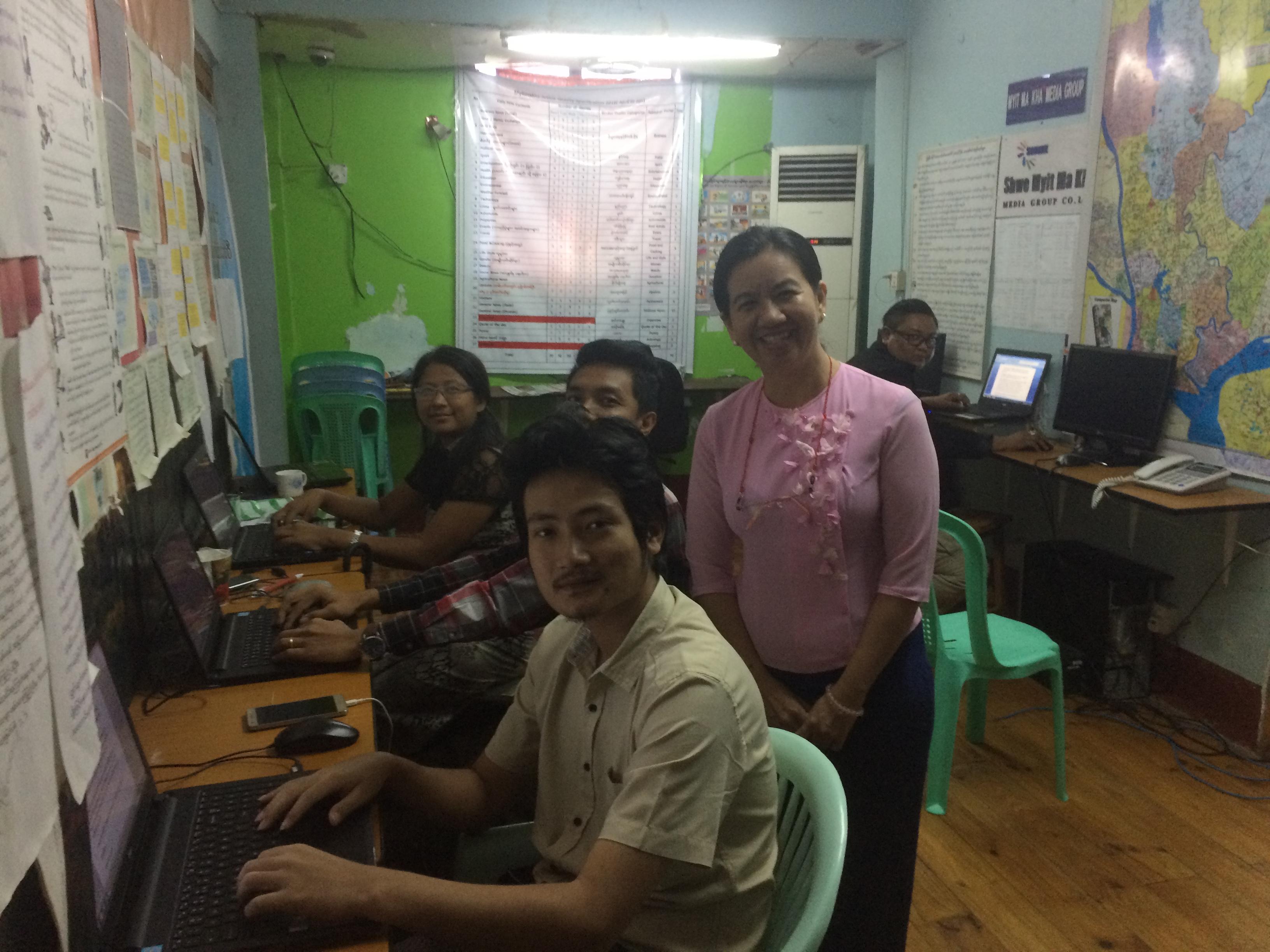 Journalist May Thingyan Hein (standing) in the newsroom at Myit Makha Media Agency in Yangon (Photo: