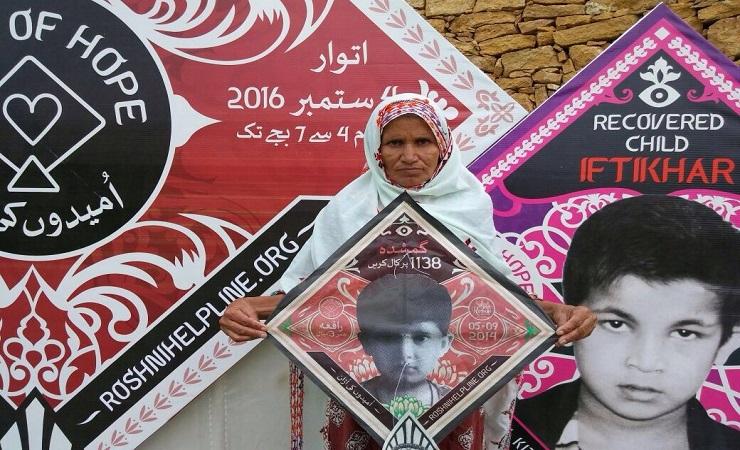 Ameeran Bibi, 60 tahun, memegang layang-layang dengan gambar cucu perempuannya bernama Rafia yang hi