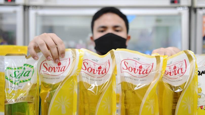 Ilustrasi: Pekerja menata minyak goreng kemasan yang dijual di salah satu minimarket di Jakarta. Rab