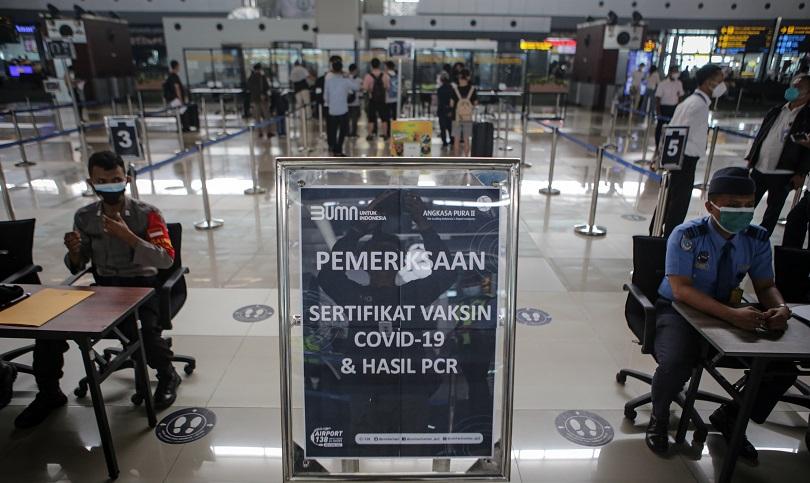 Petugas memeriksa surat vaksinasi dan tes PCR calon penumpang di Bandara Soekarno Hatta, Tangerang, 