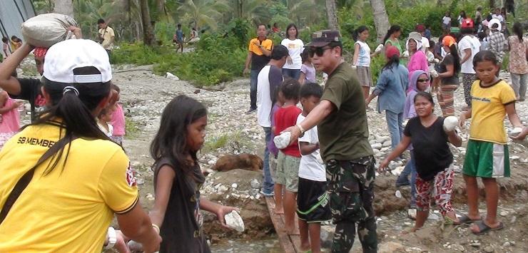 Children help rebuild their school which was buried by flash floods and mud during a typhoon (Photo:
