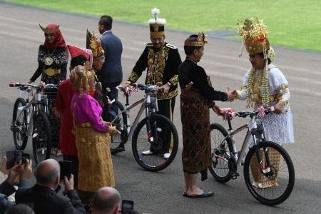 Presiden Joko Widodo (kedua kanan) memberi hadiah sepeda kepada tamu undangan yang mengenakan pakaia