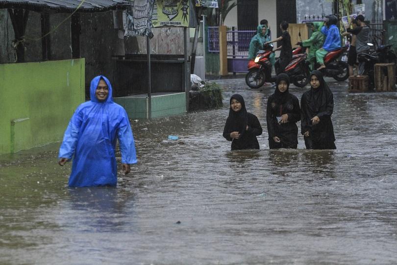 Sejumlah warga melintasi banjir di Kampung Utan, Citayam, Depok, Jawa Barat, Minggu (7/11/21). (Foto