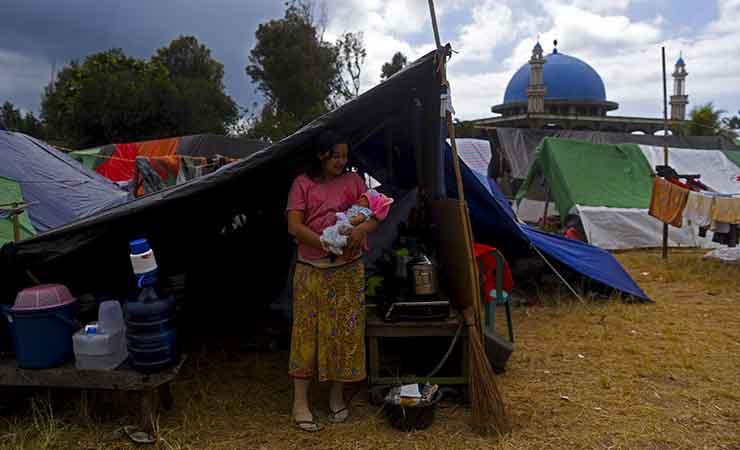 Seorang ibu menggendong anaknya di tenda pengungsian gempa lombok