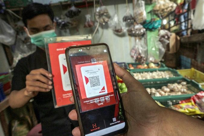 Ilustrasi: Warga bertransaksi digital menggunakan QRIS saat berbelanja di Pasar Tradisional Cibinong