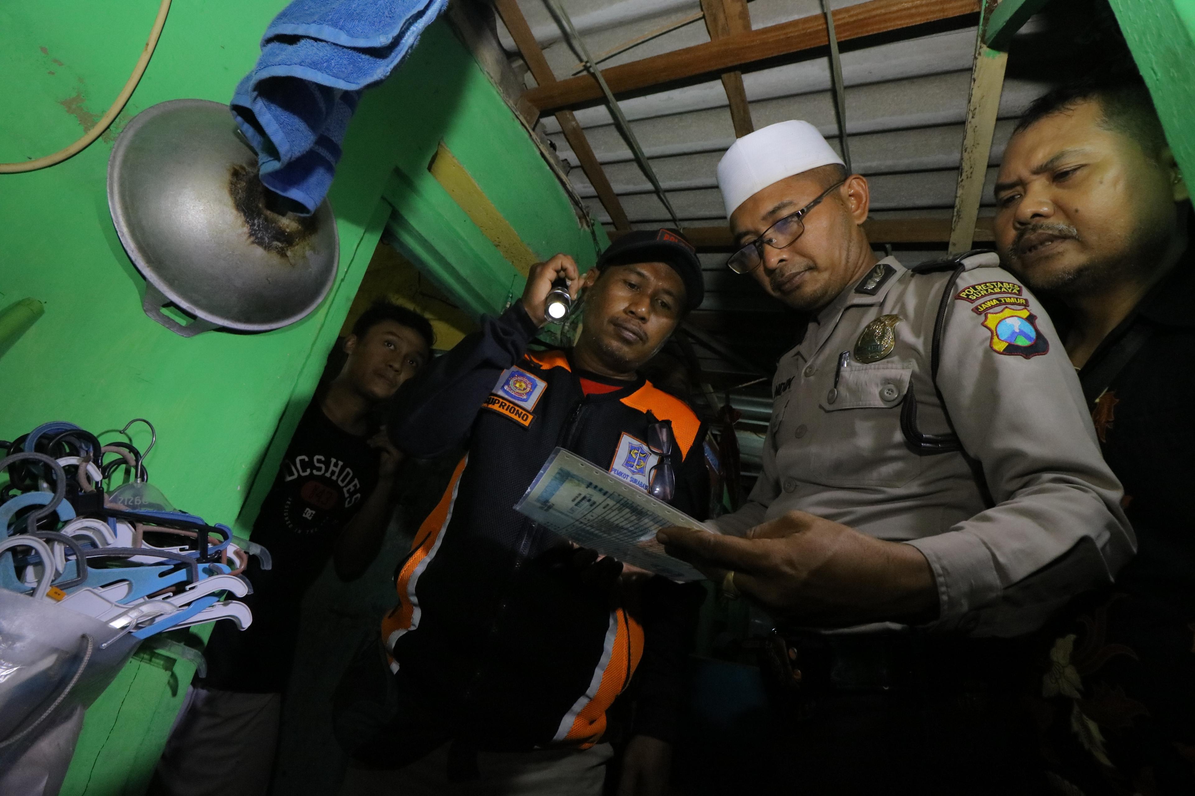 Petugas memeriksa dokumen kependudukan warga non permanen di kawasan Krembangan Bhakti, Surabaya, Ja