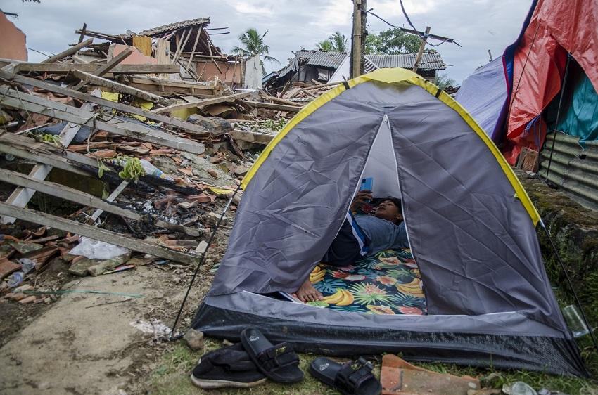 Warga korban gempa Cianjur beristirahat di tenda di sekitar reruntuhan rumah, Selasa (29/11/22). (Fo