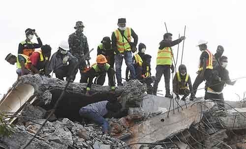 Anggota Basarnas dan relawan mencari korban yang tertimbun reruntuhan Masjid Nurul Iman akibat gempa