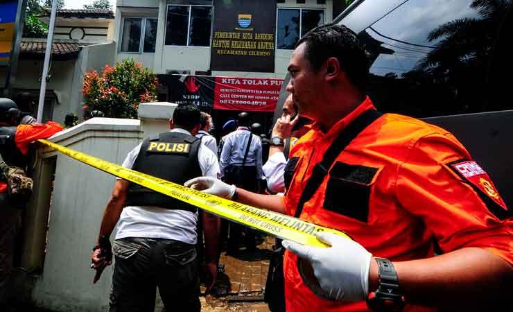 Petugas kepolisian memasang garis polisi di sekitar lokasi bom panci Bandung.