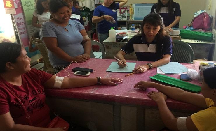 Mothers undergo counselling and implant insertion at the Bunawan Health Center. Government health wo